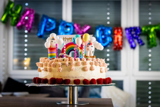 Geburtstagstorte mit Luftballons im Hintergrund